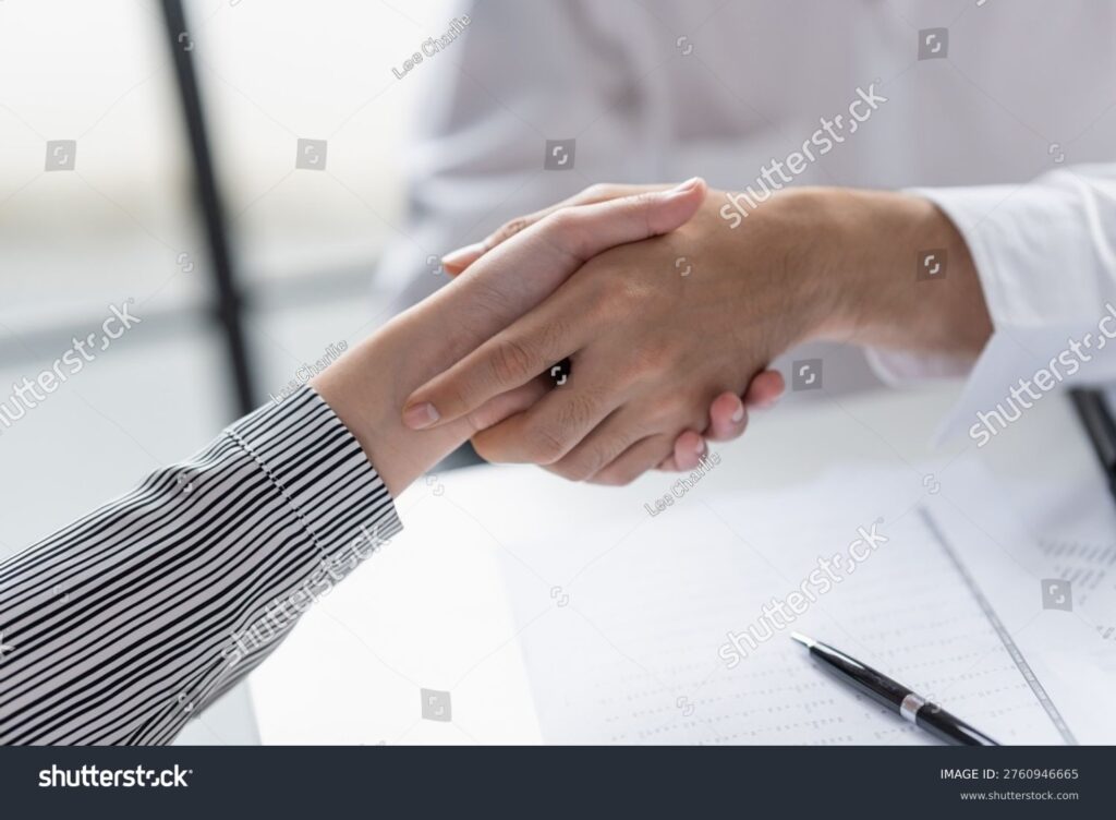 Business professionals shaking hands during a property management partnership discussion