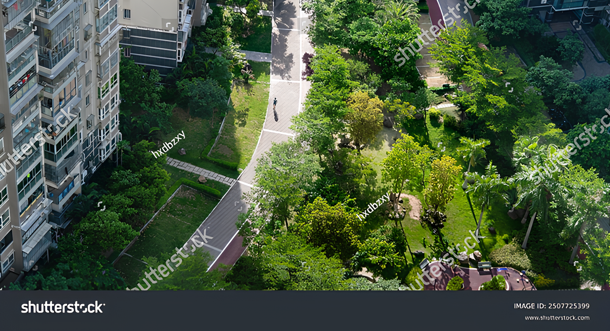 Aerial view of a landscaped green park and pedestrian pathways beside a high-rise apartment building.